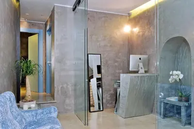 a bathroom with a glass shower with a blue chair at Mama's Home Rome in Rome