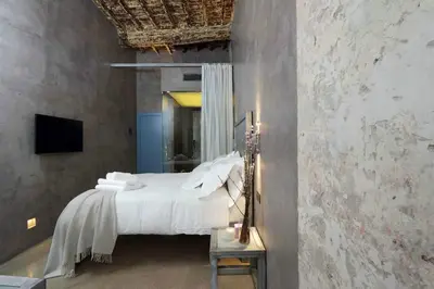 a bedroom with a bed with white sheets and a mirror at Mama's Home Rome in Rome