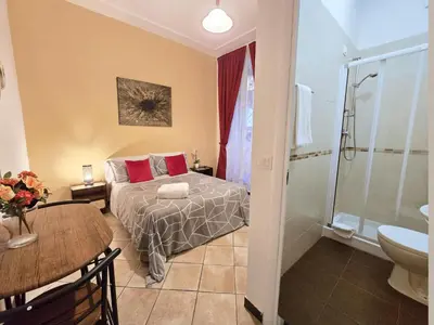 a bedroom with a bed and a bathroom with a shower at Hosting Flats Hospety Group in Rome