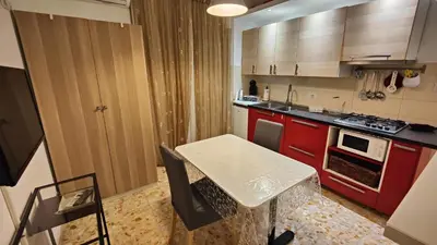 a kitchen with red cabinets and a white table in it at Sergio Tourist Rental close Tiburtina Station in Rome