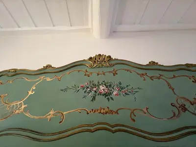 a green couch with flowers painted on it at Ascanio Twenty Six in Rome