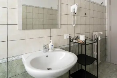 a bathroom with a sink and a phone on the wall at La Casa In Prati in Rome