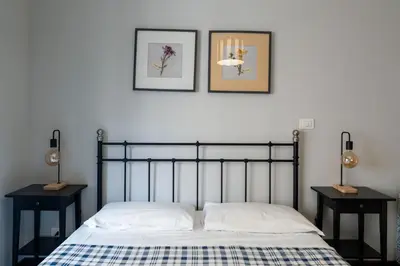 a bedroom with a bed with two nightstands and two pictures at La Casa In Prati in Rome