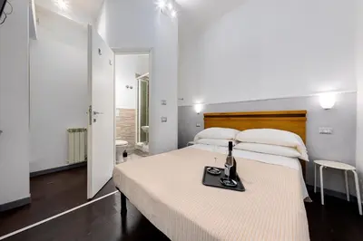 a bedroom with a bed with a bottle of wine on it at Penelope Holiday in Rome