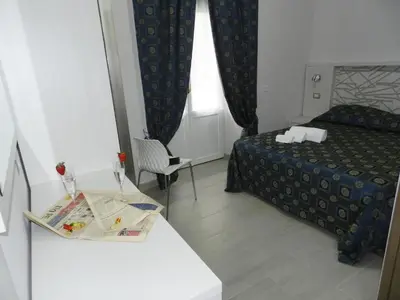 a small hotel room with a bed and a table at Vatican Rome in Rome