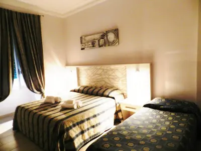 a hotel room with two beds and a window at Vatican Rome in Rome