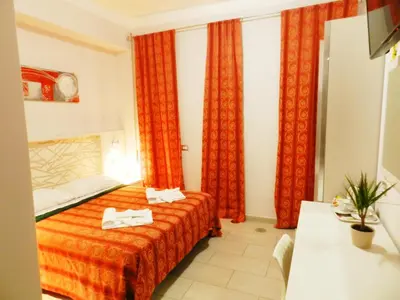 a hotel room with a bed and red curtains at Vatican Rome in Rome