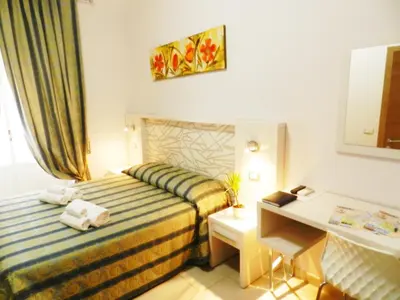 a hotel room with a bed and a desk at Vatican Rome in Rome
