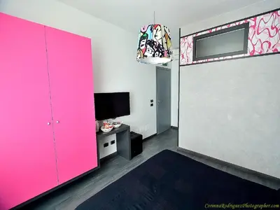 a room with a pink door and a tv at Affittacamere Tiburstation in Rome