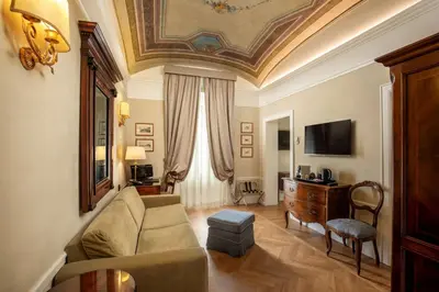 a living room with a couch and a tv at Hotel Canada, BW Premier Collection in Rome