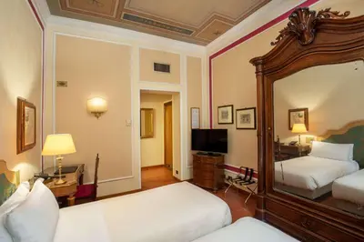 a hotel room with two beds and a mirror at Hotel Canada, BW Premier Collection in Rome