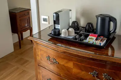 a wooden dresser with a coffee maker on top of it at Hotel Canada, BW Premier Collection in Rome