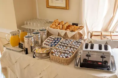 a table topped with baskets of pastries and a breakfast at Hotel Canada, BW Premier Collection in Rome