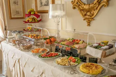 a buffet with many different types of food on a table at Hotel Canada, BW Premier Collection in Rome