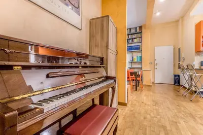 an old piano in a room with a table at Il gazebo a Monteverde in Rome