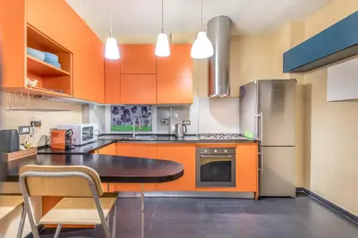 a kitchen with orange cabinets and a black counter top at Il gazebo a Monteverde in Rome