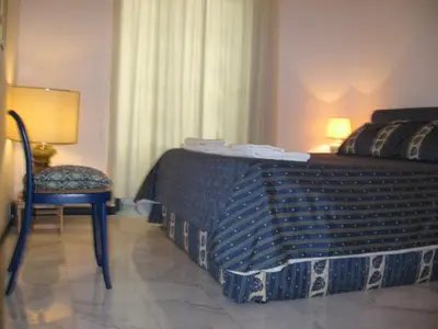 a bedroom with a large bed and a chair at 2 Be Home Colosseo in Rome