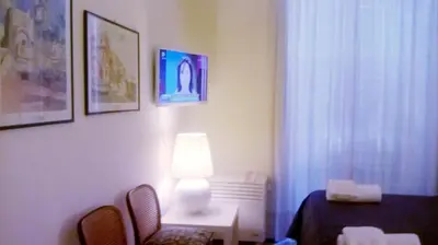 a room with a lamp and a table and chairs at 2 Be Home Colosseo in Rome