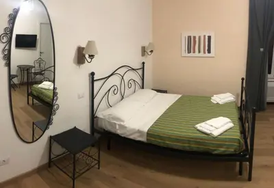a bedroom with a bed and a large mirror at Maison Vaticana in Rome