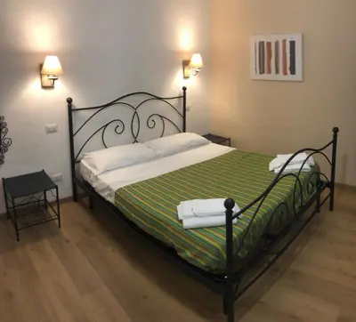 a bedroom with a bed with a green and white blanket at Maison Vaticana in Rome
