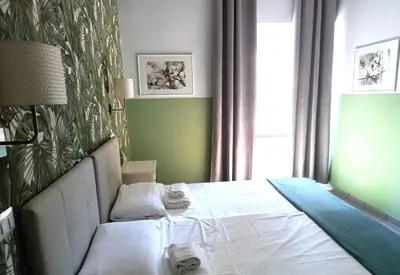 a bedroom with a white bed with a green wall at Sweet Dreams Roma in Rome
