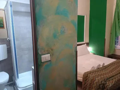 a bathroom with a shower and a bed in a room at Enjoy Roma in Rome