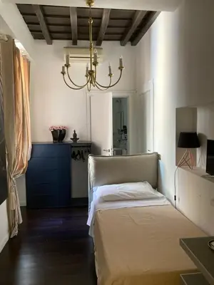 a bedroom with a bed and a chandelier at D.R.Rome Spanish Luxury Suites in Rome