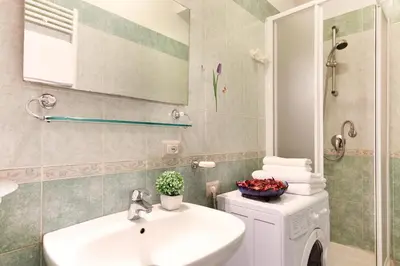 a bathroom with a sink and a washing machine at San Pietro's Home in Rome