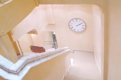 a clock on the wall next to a stairway at Colosseo Studio Suite in Rome