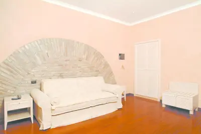 a living room with a white couch and a brick wall at Colosseo Studio Suite in Rome