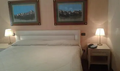 a bedroom with a white bed and two lamps at Colosseo Studio Suite in Rome