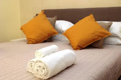 a bed with two towels and pillows on it at Cardinal Vatican Inn in Rome