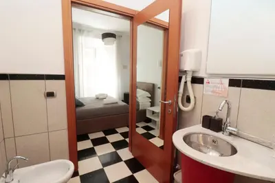 a bathroom with a sink and a bathroom with a bed at Cardinal Vatican Inn in Rome