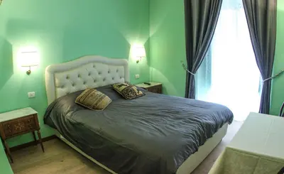 a green bedroom with a bed with two pillows at La Reggia dei Principi in Rome