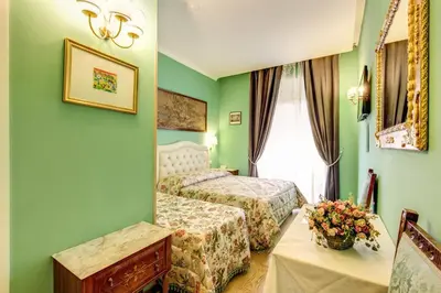 a hotel room with two beds and a window at La Reggia dei Principi in Rome