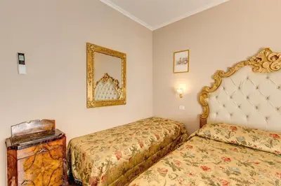 a bedroom with two beds and a mirror at La Reggia dei Principi in Rome