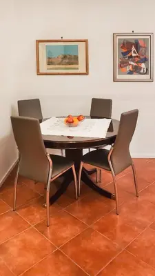 a table with three chairs and a table with fruit on it at Domus Chiara al Colosseo in Rome