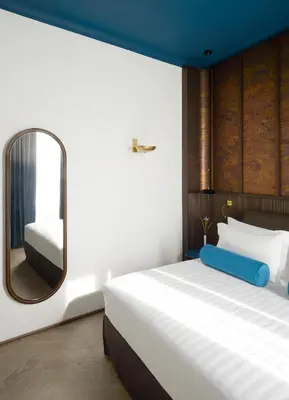 a bedroom with a large bed and a mirror at Palazzo Velabro, a Member of Design Hotels in Rome
