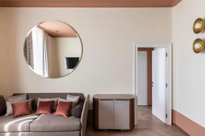 a living room with a couch and a mirror at Palazzo Velabro, a Member of Design Hotels in Rome