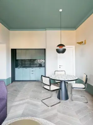 a room with a table and chairs and a kitchen at Palazzo Velabro, a Member of Design Hotels in Rome