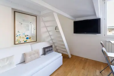 a white living room with a white couch and a tv at Cozy Suite Pigneto in Rome