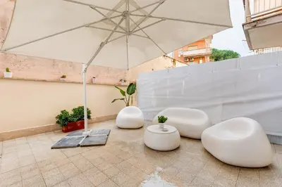 three white chairs and an umbrella on a building at Vatican 96 Degli Ubaldi Charming Suite with terrace in Rome
