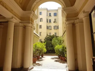 an archway leading to a building with potted plants at Popolo square deluxe flat in Rome