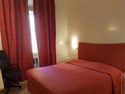 a bedroom with a red bed and a chair at Popolo square deluxe flat in Rome