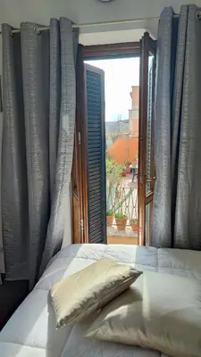 a bed with a pillow in front of a window at CASETTE DEI QUINTILI in Rome
