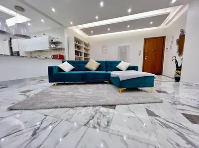 a blue couch in a living room with a marble floor at Lussuoso 130 MQ zona Cipro in Rome