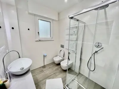 a bathroom with two toilets and a shower and a sink at Lussuoso 130 MQ zona Cipro in Rome