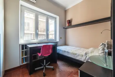 a bedroom with a bed and a desk and a chair at GuestHost - MM Cipro Elegant Apartment in Rome