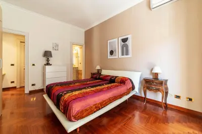 a bedroom with a bed and a wooden floor at GuestHost - MM Cipro Elegant Apartment in Rome