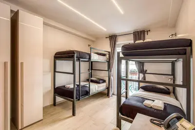 a room with three bunk beds and a table at Aurelia Vatican Suites in Rome